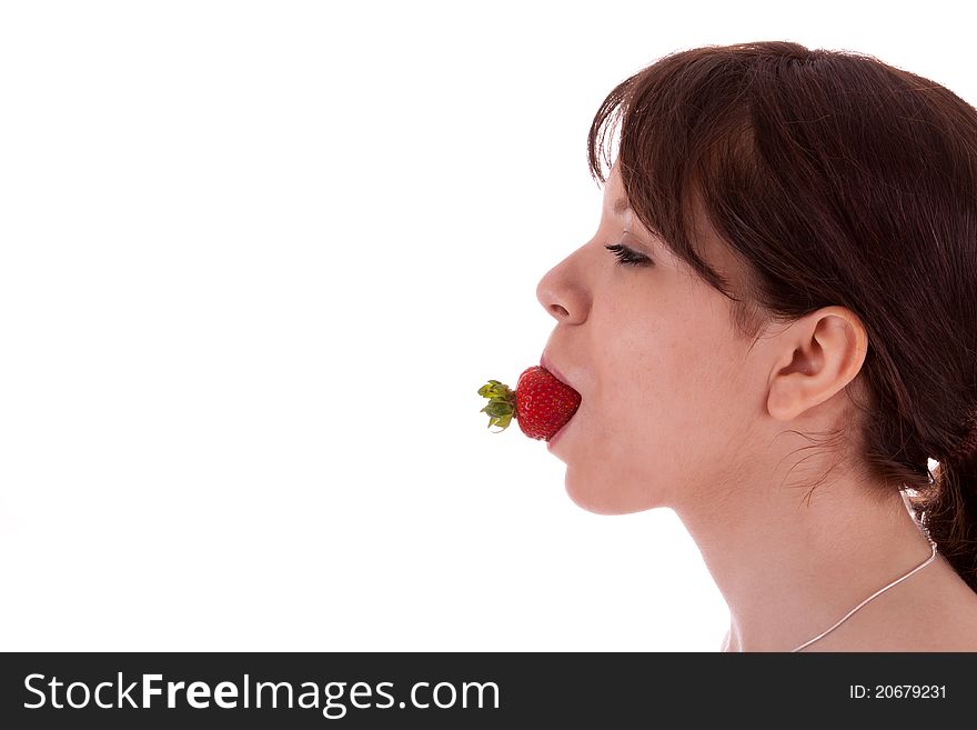The pretty young woman has a strawberry in her mouth. The pretty young woman has a strawberry in her mouth