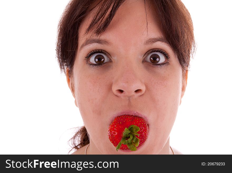 The pretty young woman has a strawberry in her mouth. The pretty young woman has a strawberry in her mouth