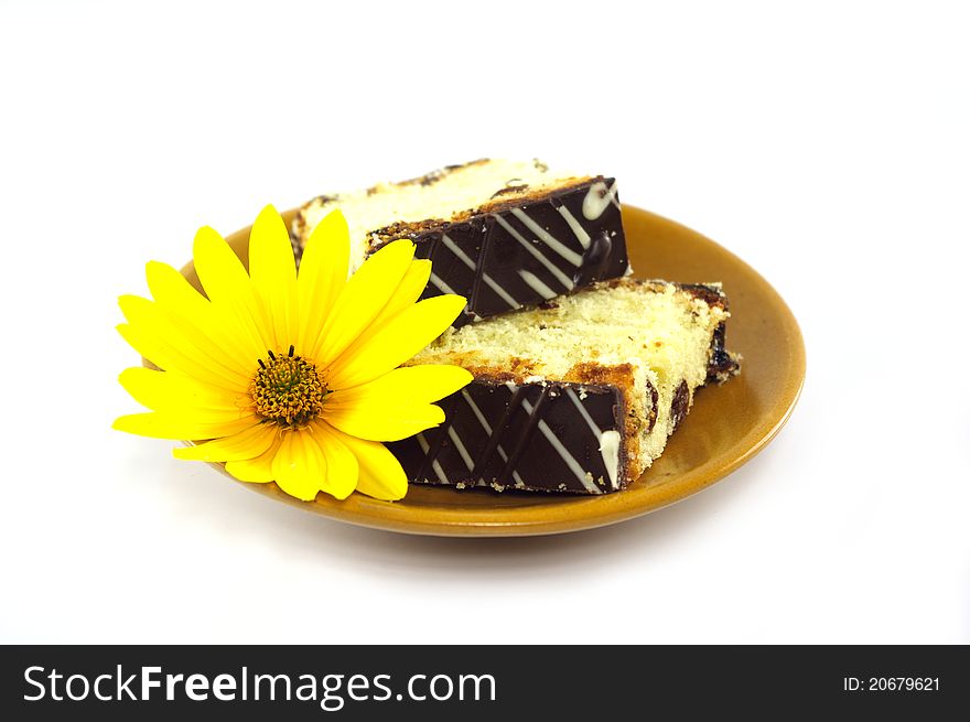 Sliced cake decorated with yellow flower on white background. Sliced cake decorated with yellow flower on white background