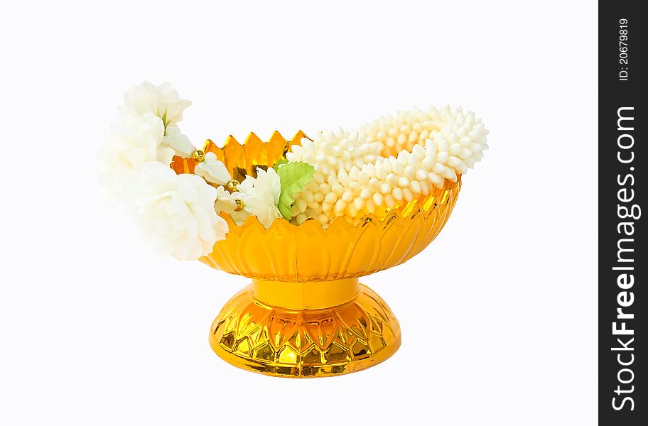 Jasmine garland on gold tray with pedestal, white background.