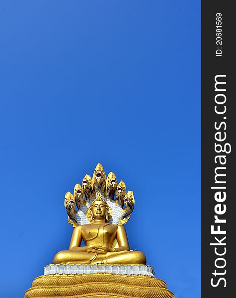 Gold Buddha statue over blue sky