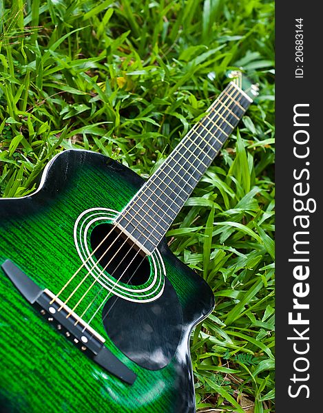 Acoustic guitar with green grass background