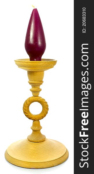 Wooden candlestick with a purple candle on top.