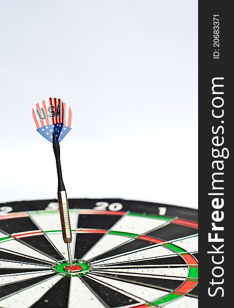 Dart in center of dartboard with white background. Dart in center of dartboard with white background