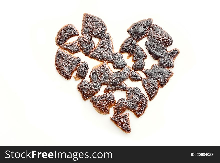 Broken heart isolated on a white background made of burnt chocolate. Broken heart isolated on a white background made of burnt chocolate.