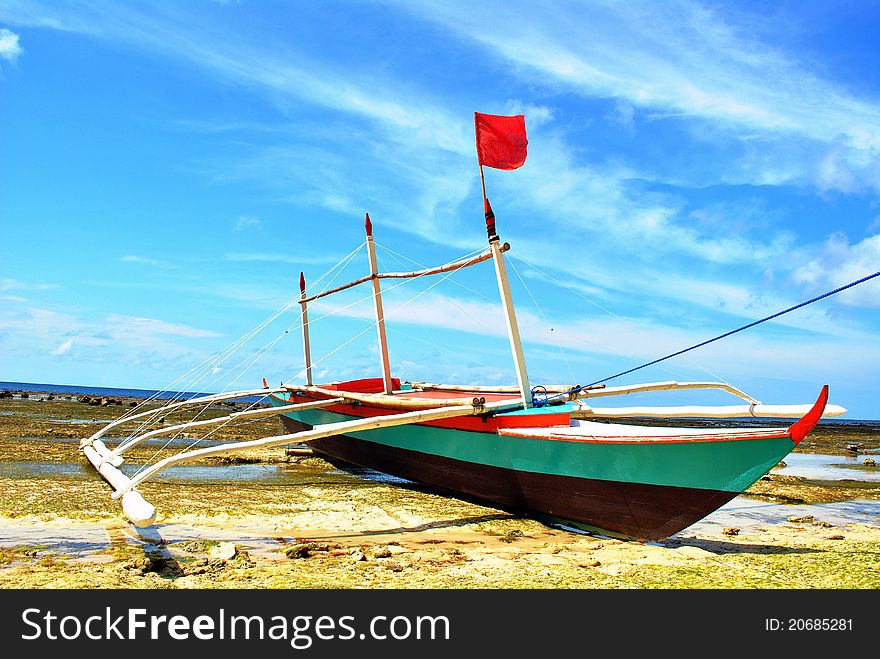 Fishing boat docked at low tide.