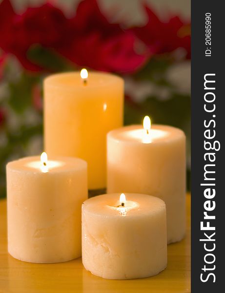 Four lit candles sitting on surface in hierarchal arrangment