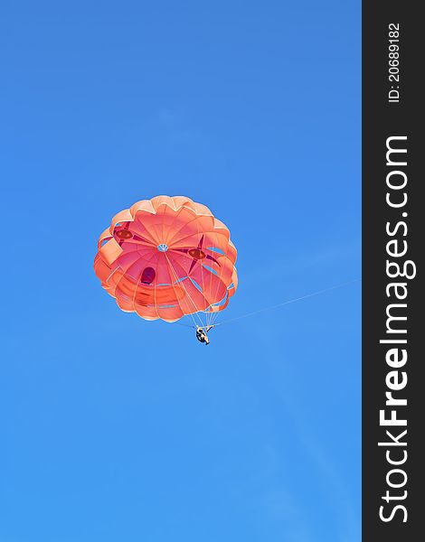 A parachute with the person in the background of blue sky. A parachute with the person in the background of blue sky