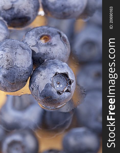 Studio- shot of blueberries with waterdrops on a glass plate.