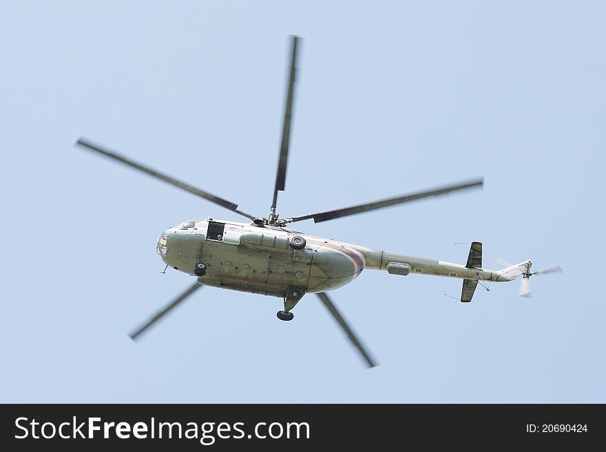 The image of helicopter flies under the sky