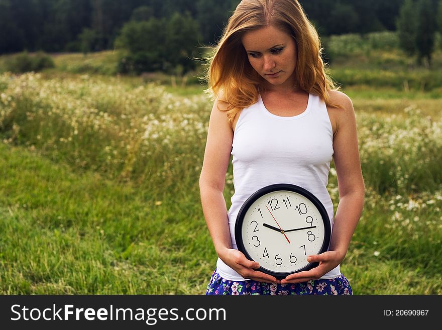 Young woman with a wall clock outdoor