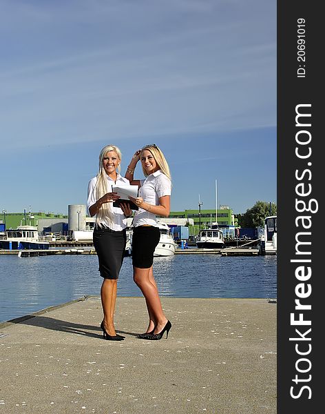 Two Girls With The Documents Standing On The Pier