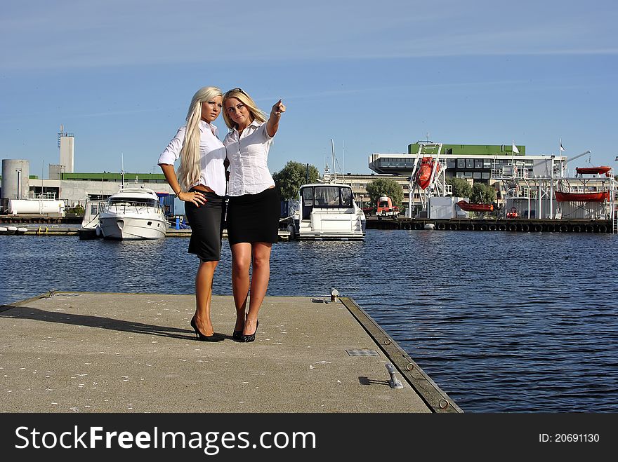 Two girls blonde stand on the pier