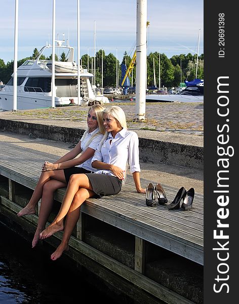 Two girls resting on the pier