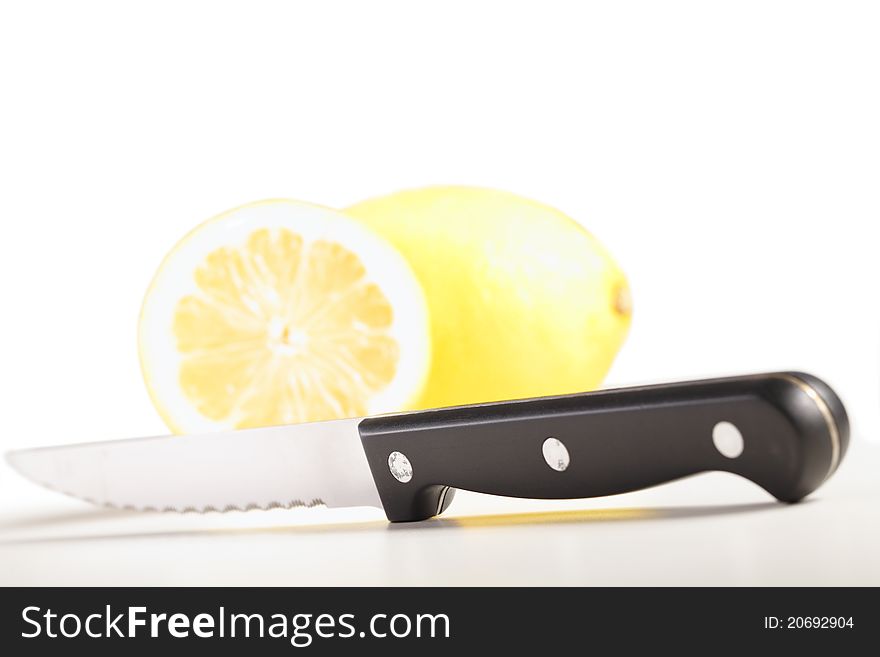 Kitchen knife isolated on white with lemons in the background