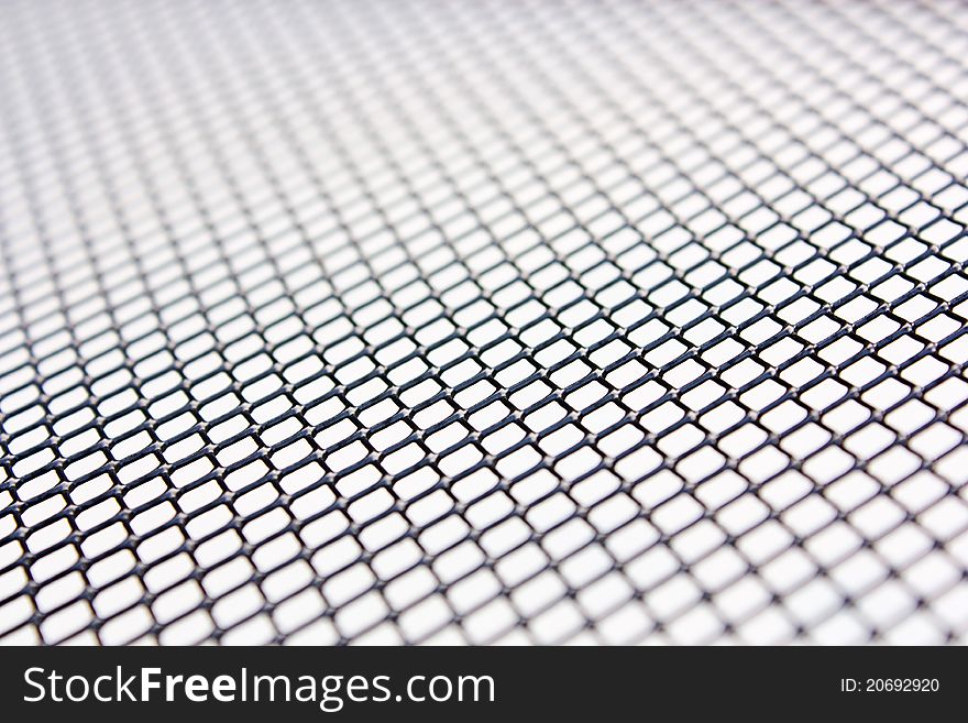 Metal grill of diamond shaped mesh, used in the construction industry, against black. Metal grill of diamond shaped mesh, used in the construction industry, against black.
