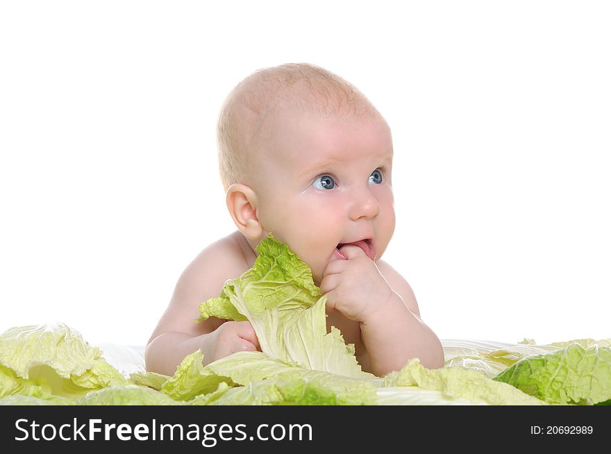 Small child sitting among the cabbage leaves