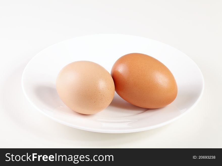 Two differently colored eggs on a saucer. Two differently colored eggs on a saucer