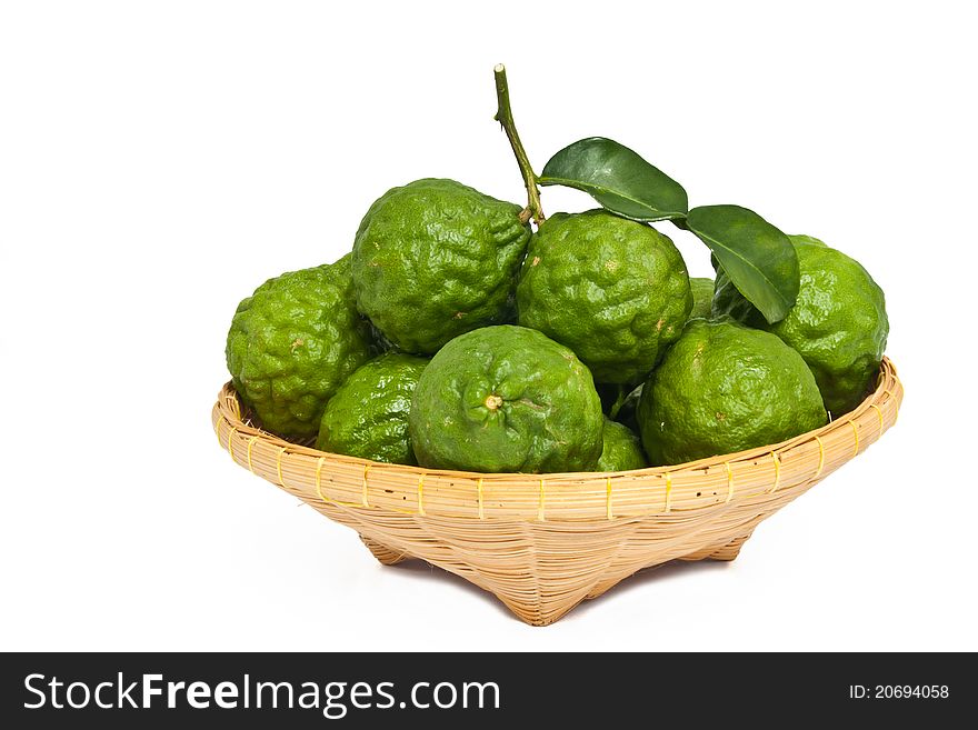 Kaffir limes and bamboo basket isolated on white background