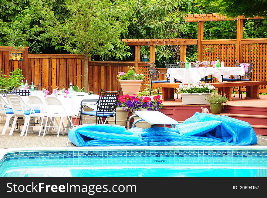Lovely poolside patio and deck with fencing and flowers. Lovely poolside patio and deck with fencing and flowers