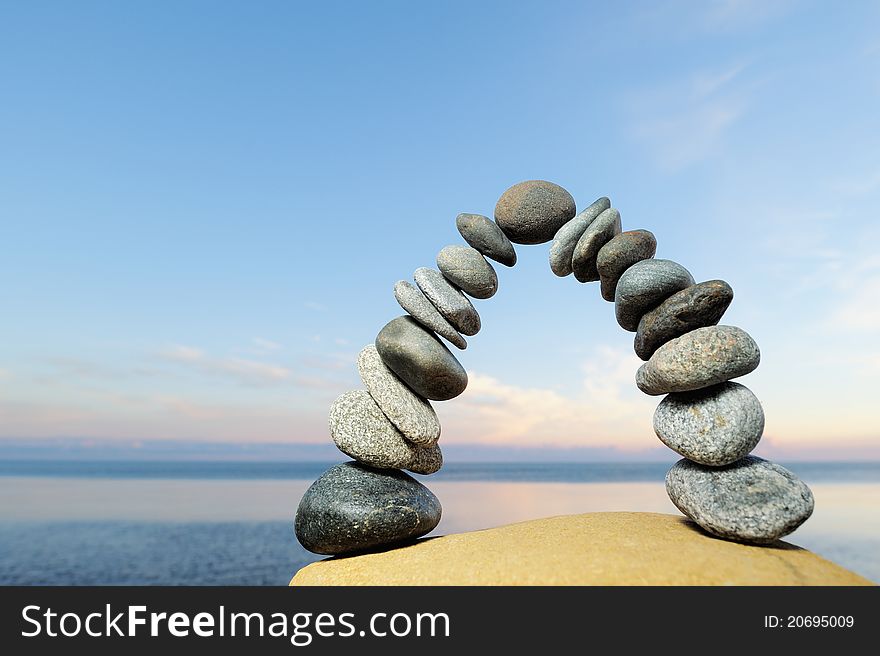 Grey pebbles are formed as curve on the seacoast. Grey pebbles are formed as curve on the seacoast