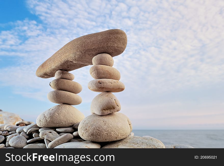 Long horizontal stone is between a stack of pebbles. Long horizontal stone is between a stack of pebbles