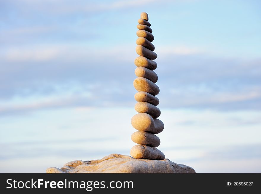 White pebbles composed one on another, against the sky