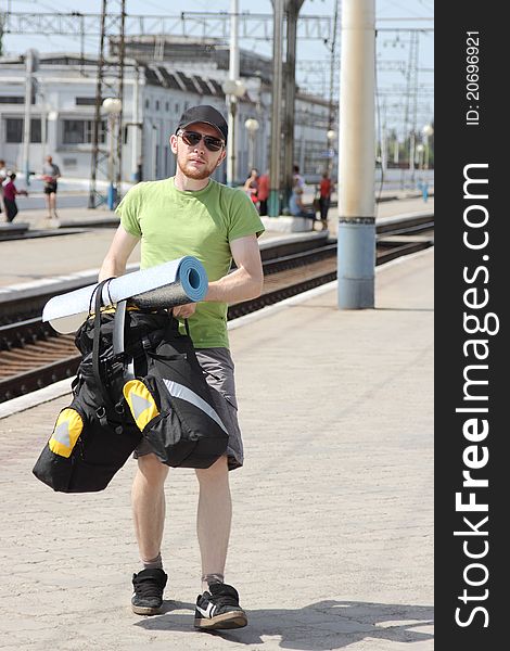 Bicycle tourist with backpack walking and railroad station