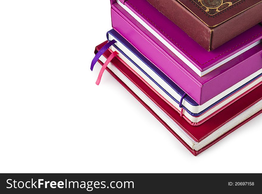 A stack of books and notebooks on a white background