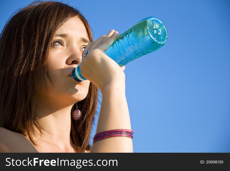 Young woman drinking water at outdoors workout