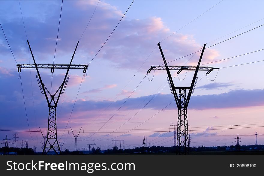 High voltage electricity pylon over evening sky