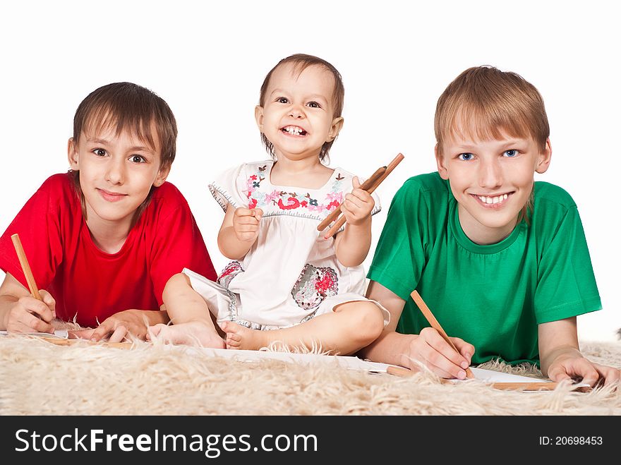 Portrait of a three children drawing on carpet