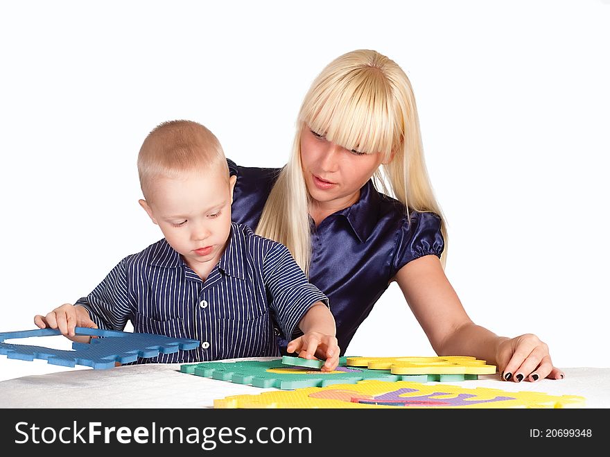 Cute mom and her son playing at table. Cute mom and her son playing at table