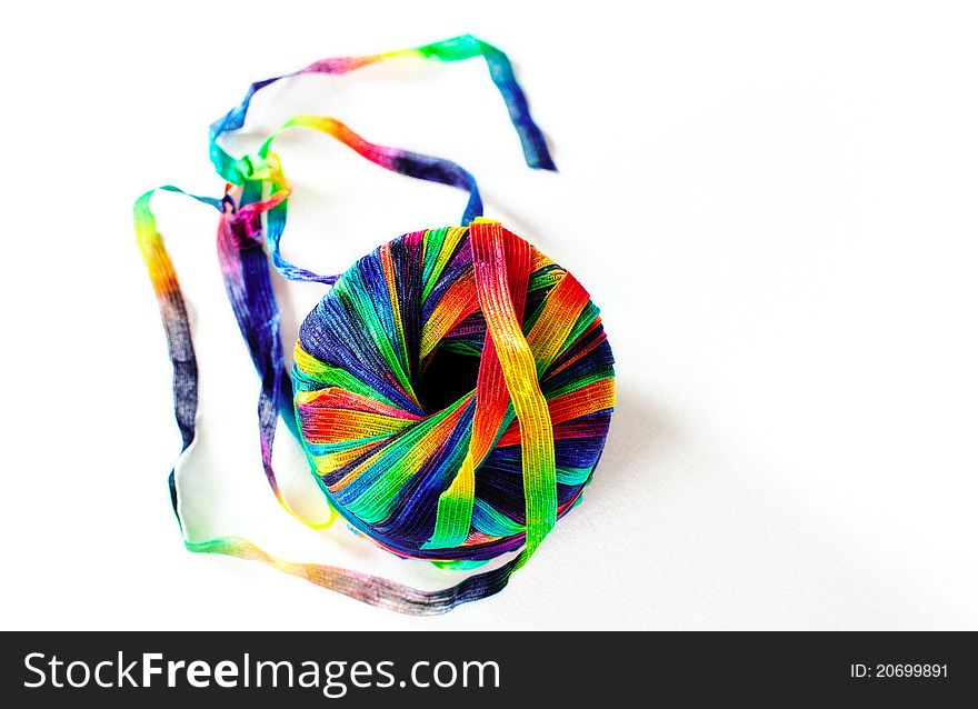 Closeup of a spool of silk multi colored ribbon