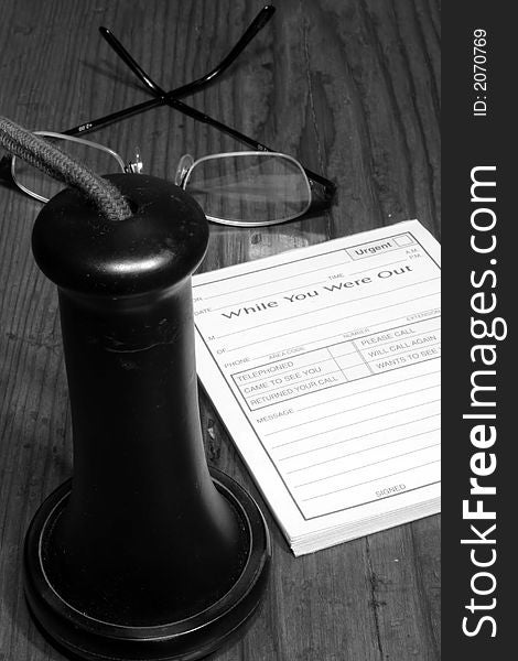 This is an image of a vintage switchboard - phone earpiece, glasses, and message pad. This is an image of a vintage switchboard - phone earpiece, glasses, and message pad.