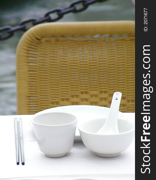 A set of chinese cutlery set on a white table cloth and a river behind. A set of chinese cutlery set on a white table cloth and a river behind