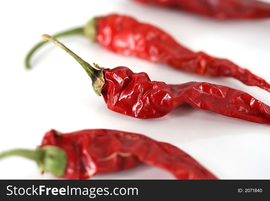Spicy red chili peppers on a white background. Spicy red chili peppers on a white background
