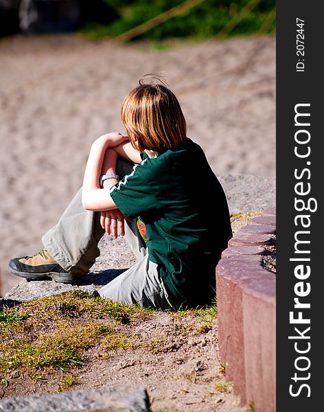 Child makes a break during playing with its friends on playground. Child makes a break during playing with its friends on playground