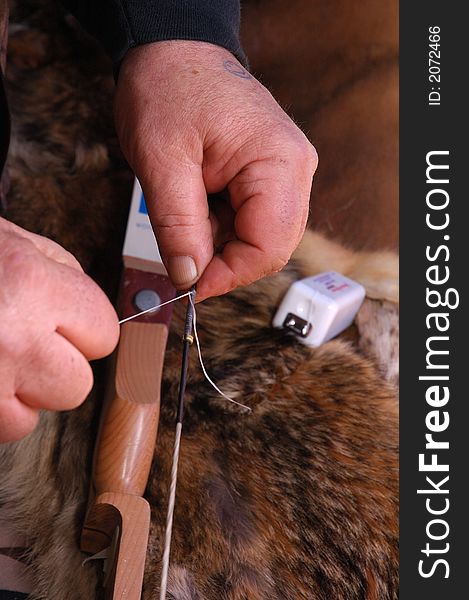 Archer repairing bow string with dental floss