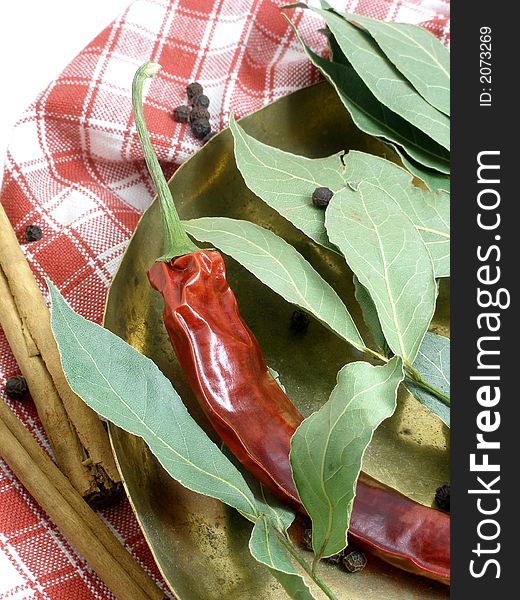 Dried chillis, bay leaves in a coper scale tray. Dried chillis, bay leaves in a coper scale tray