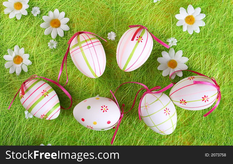 Closeup of several Easter eggs over green grass.