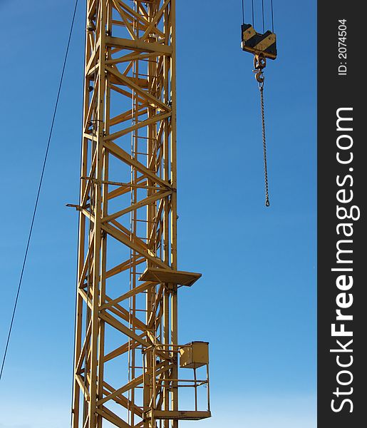 Closeup portrait of yellow crane in blue sky. Closeup portrait of yellow crane in blue sky