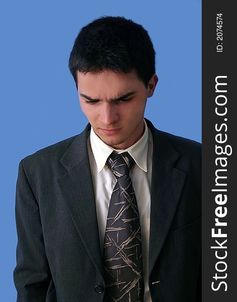 Young businessman angry isolated on blue