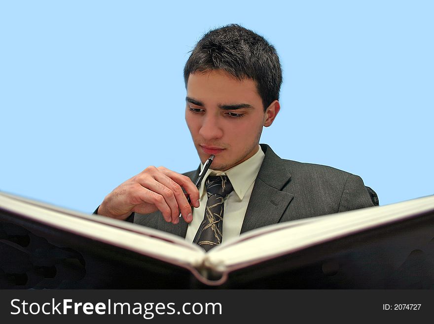 Young businessman reading a book,isolated on blue