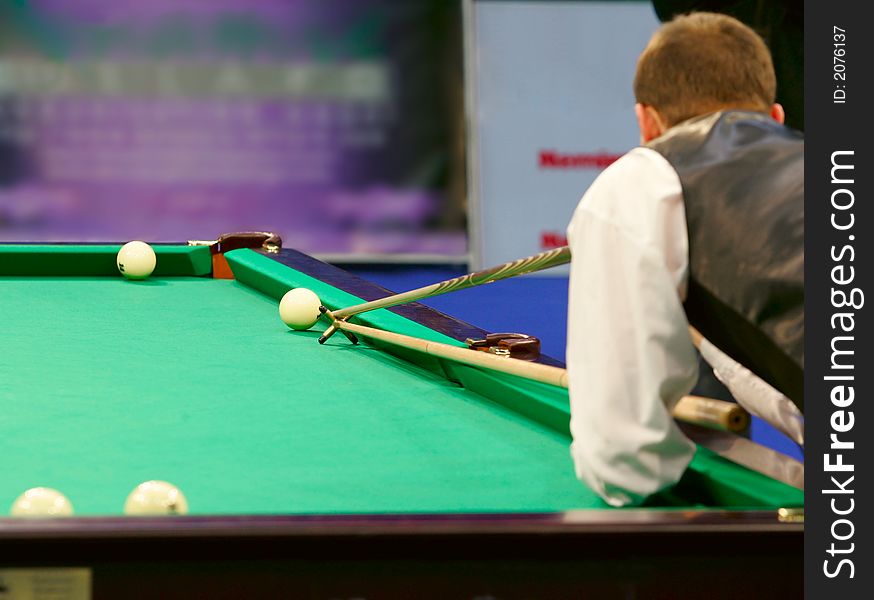 The player in billiards shooting on a ball