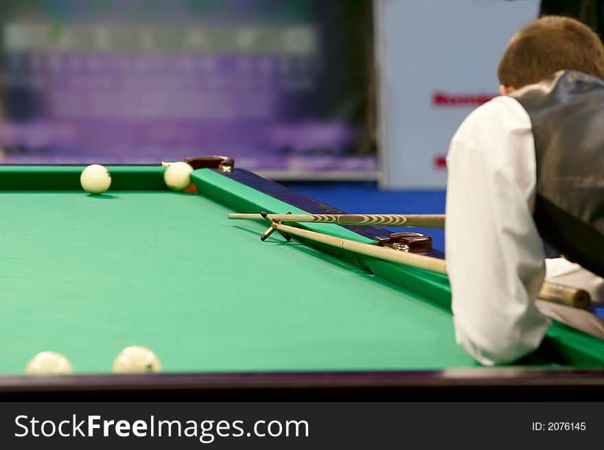 The player in billiards shooting on a ball