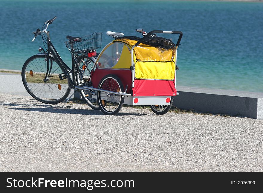 Bike and children cab on the blue water background. Bike and children cab on the blue water background