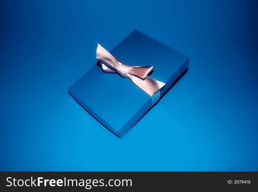 A blue gift box with a silver ribbon. A blue gift box with a silver ribbon.