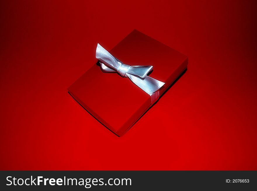A red gift box with a silver ribbon. A red gift box with a silver ribbon.