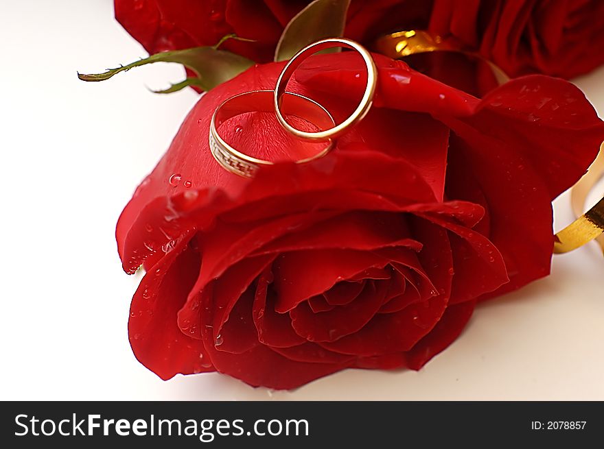 A bouquet of three roses and wedding-rings